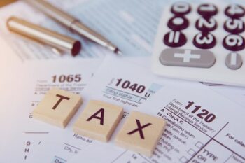 Tax Season With Wooden Alphabet Blocks, Calculator, Pen On 1040